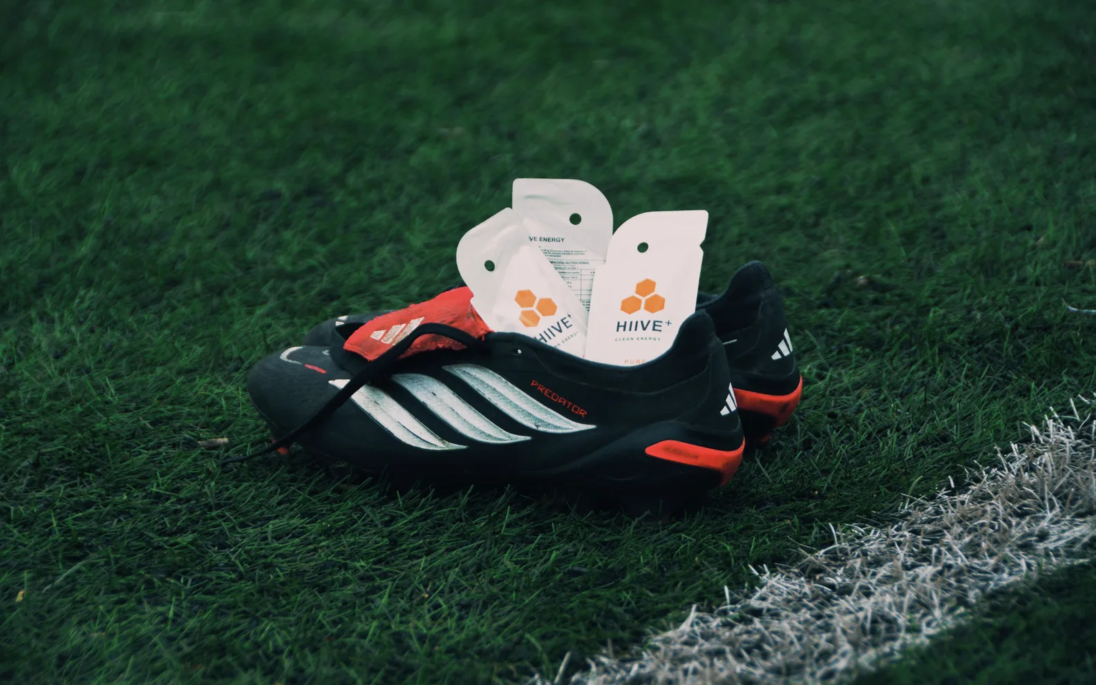 Botines de fútbol con dos geles HIIVE PURE sobre el césped, listos para la actividad